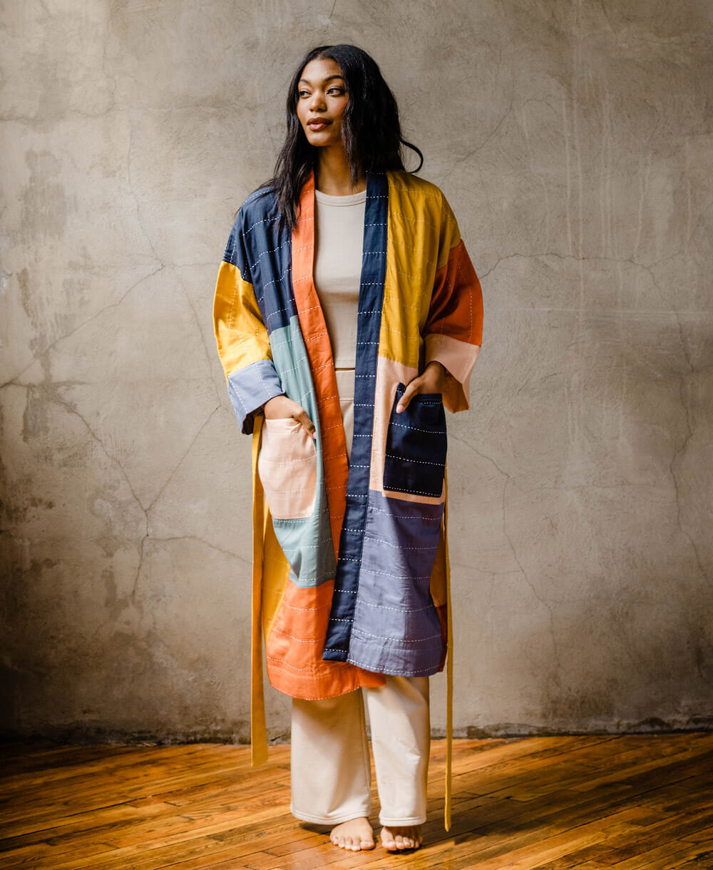woman wearing long organic cotton lightweight robe in colorblock design with two front pockets