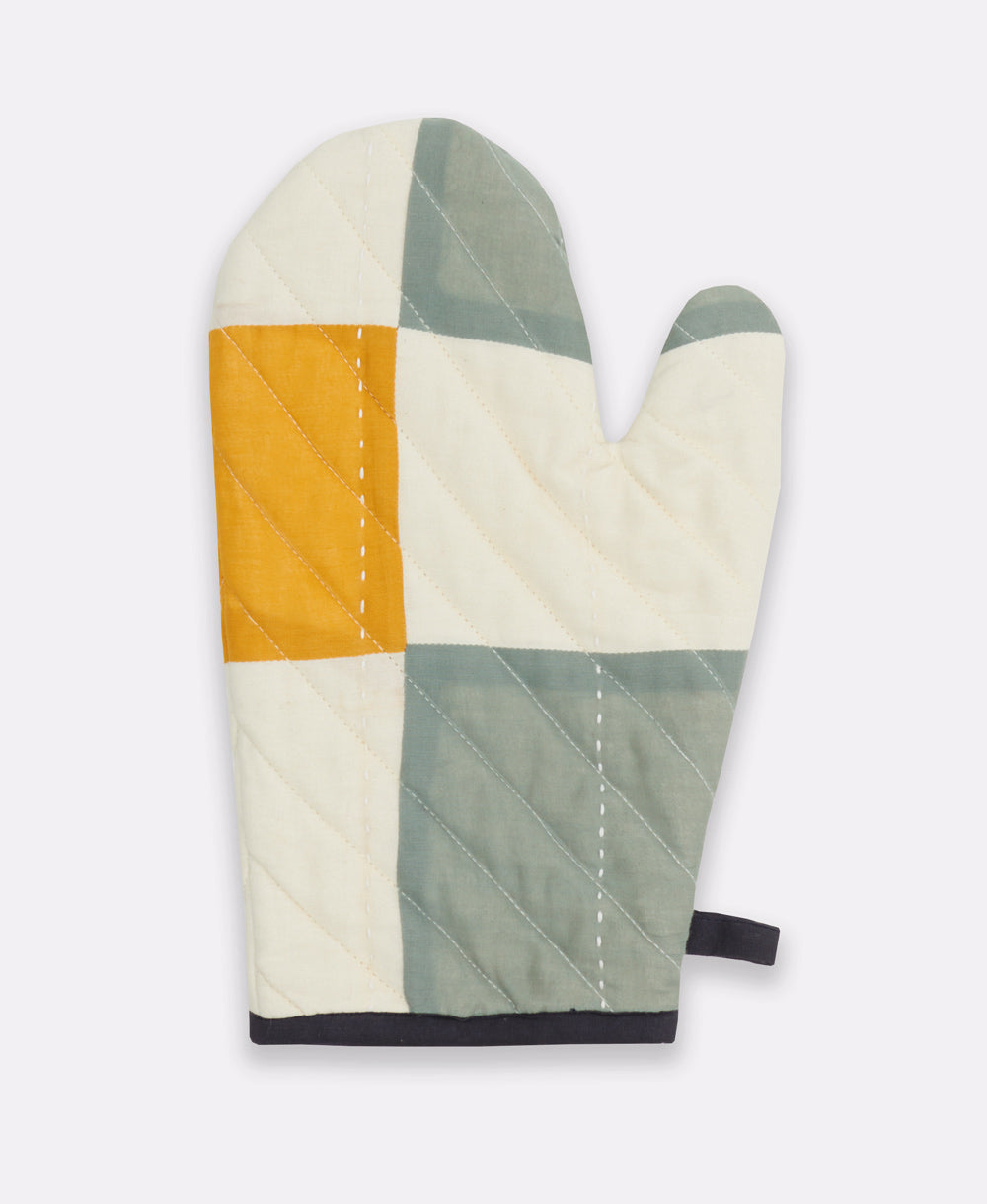 Patchwork-style oven mitt with geometric pattern on a white background