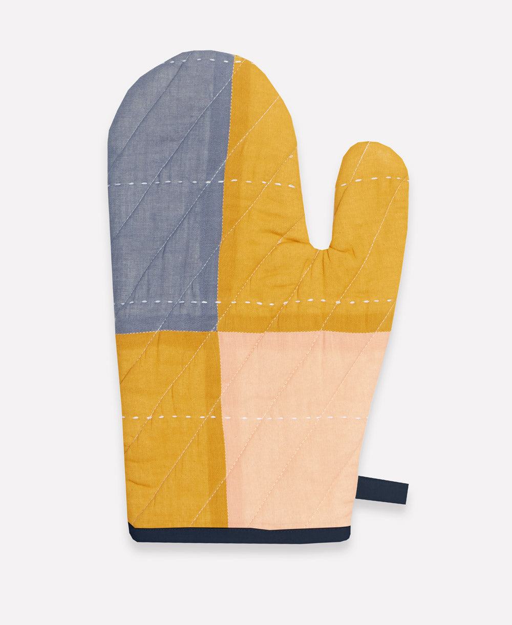 Color-blocked oven mitt with blue, yellow, and pink sections on a white background
