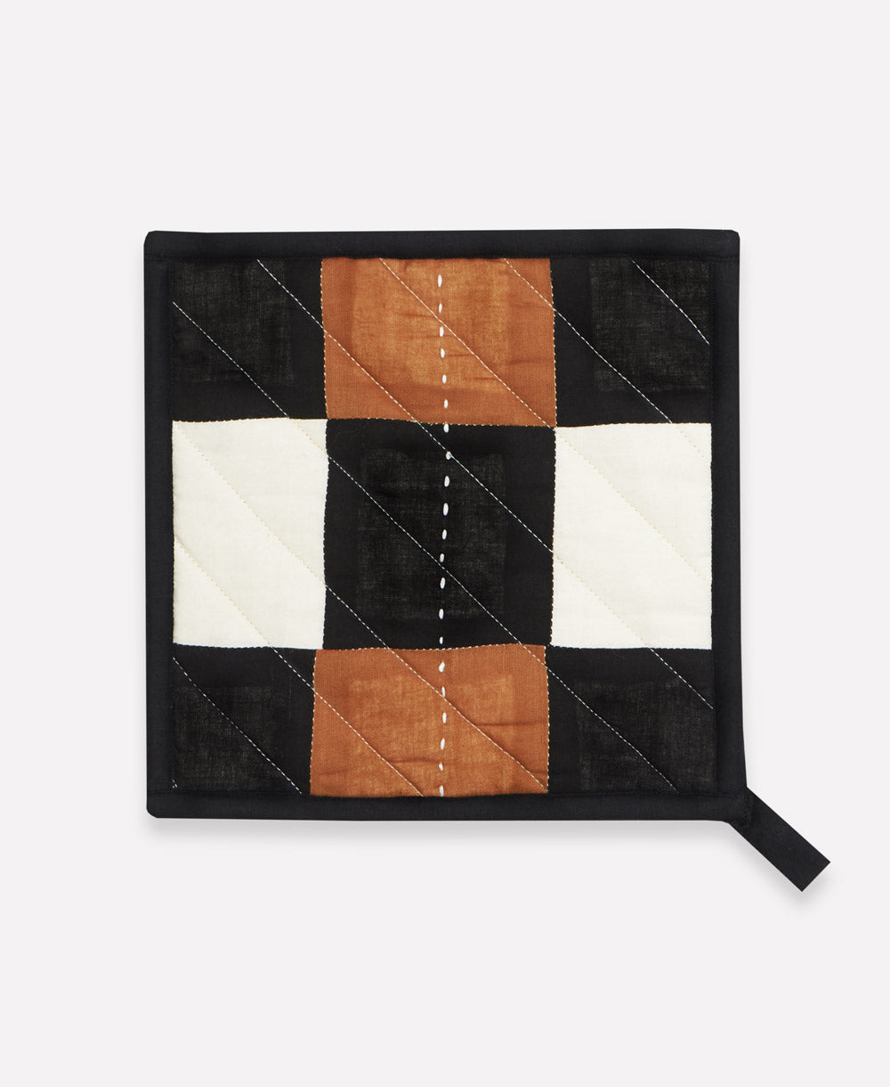 Quilted pot holder with a checkered pattern on a white background