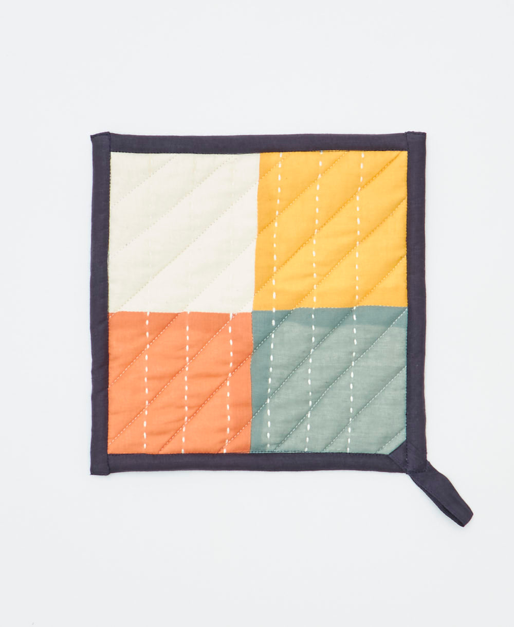 Quilted potholder with geometric pattern on a white background