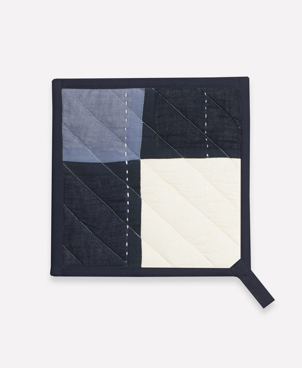 Quilted potholder with geometric pattern on a white background