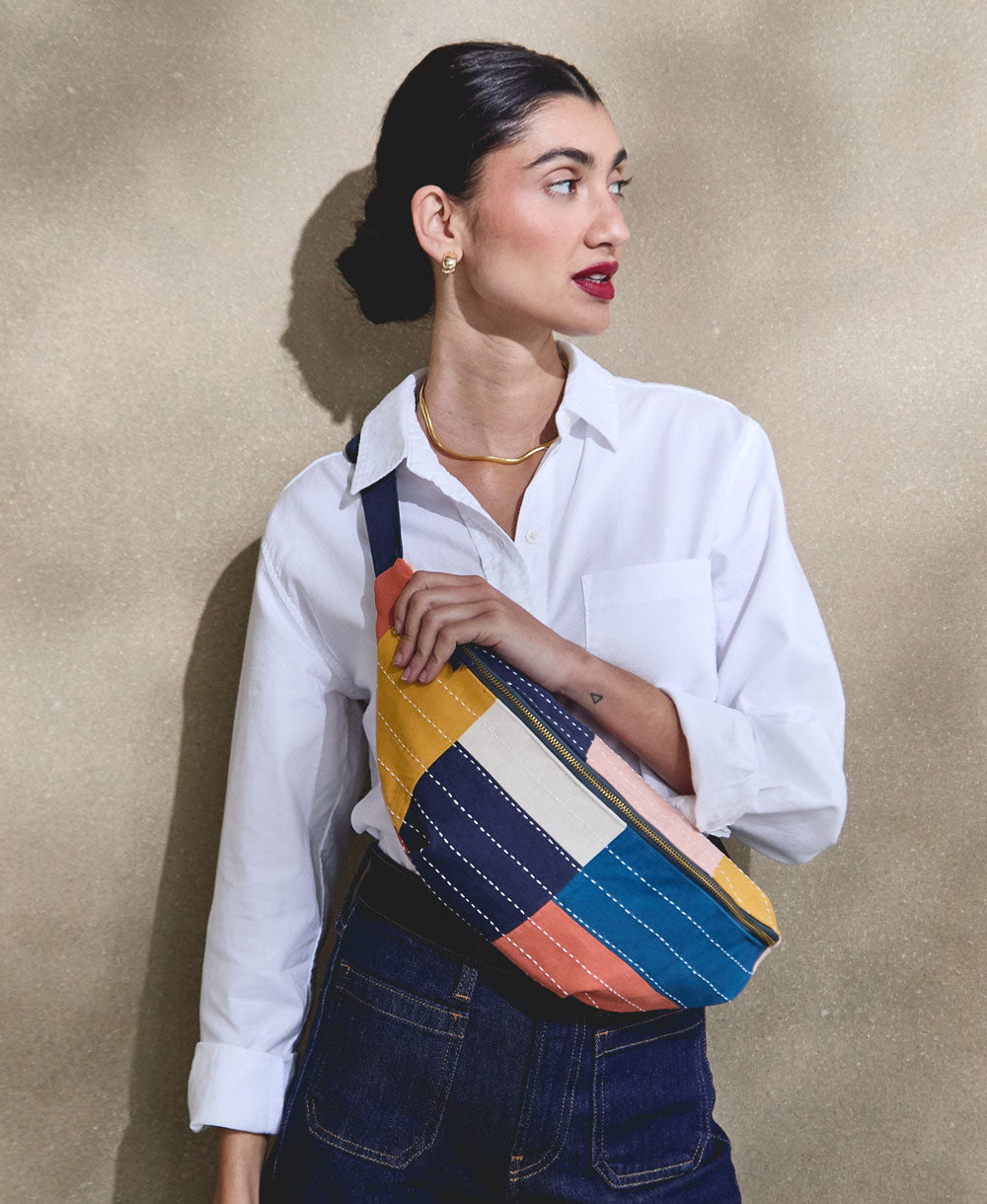 woman wearing a colorblock checkered sling crossbody bag across chest