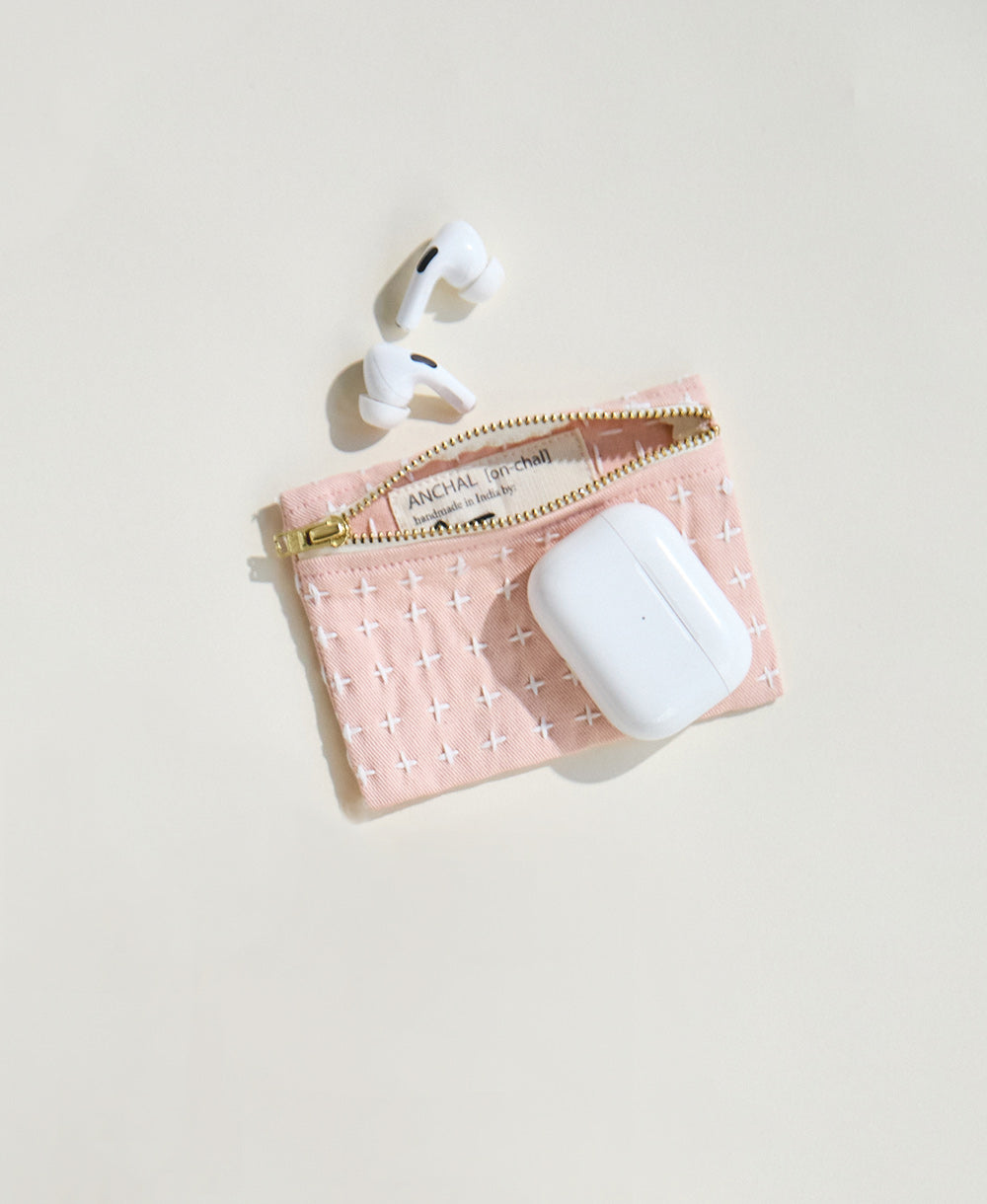 pink coin purse holding apple airpods