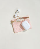 pink coin purse holding apple airpods