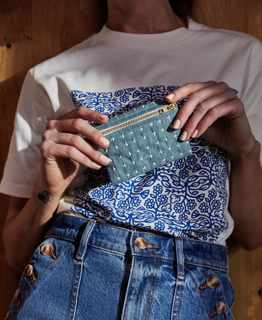 woman holding spruce green cross-stitch coin purse