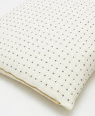 close up detail of white euro sham with black cross-stitch embroidery