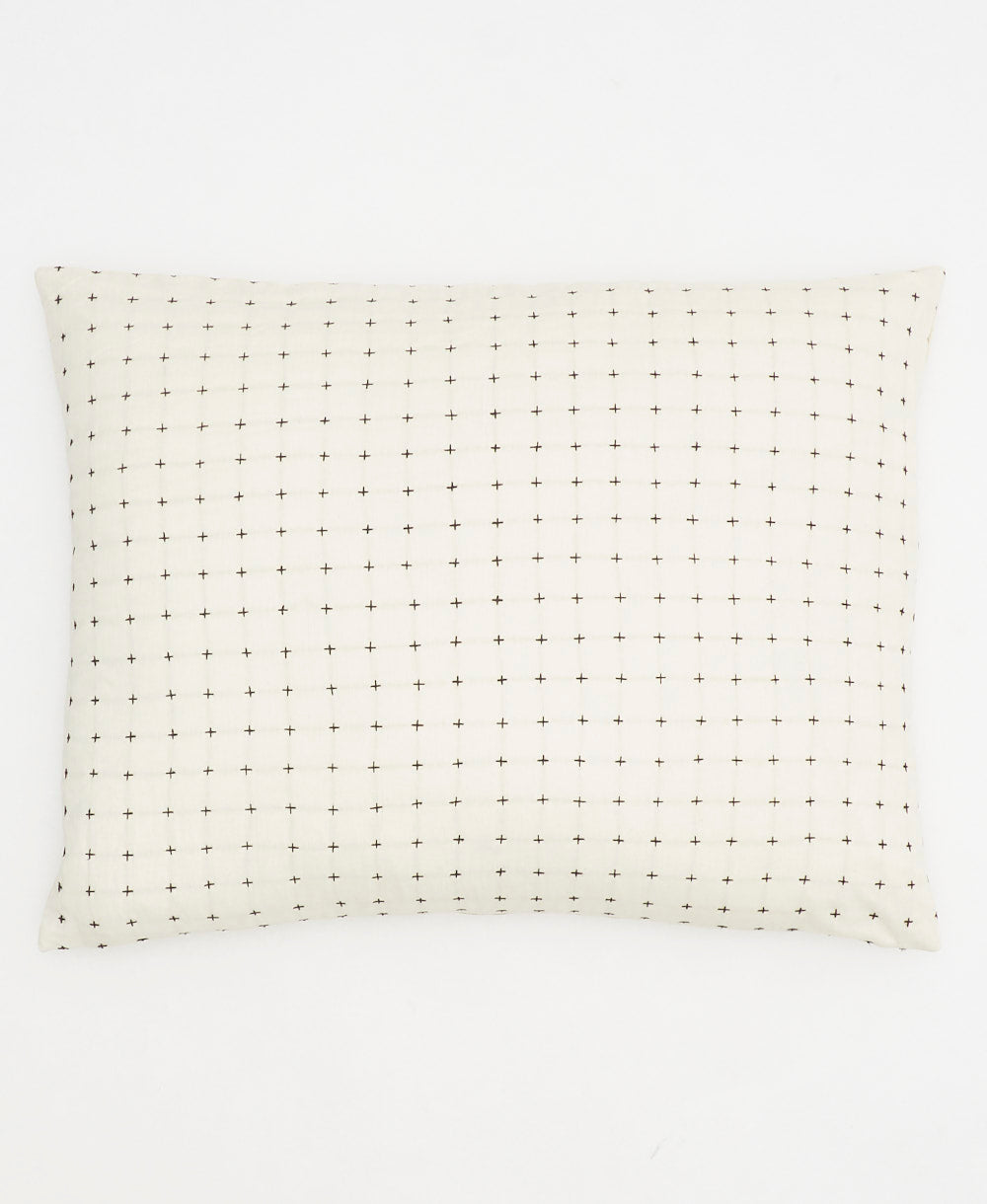 White pillow with black dot pattern on a white background