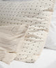 embroidered bed sham on all white bed with cross-stitch design by Anchal