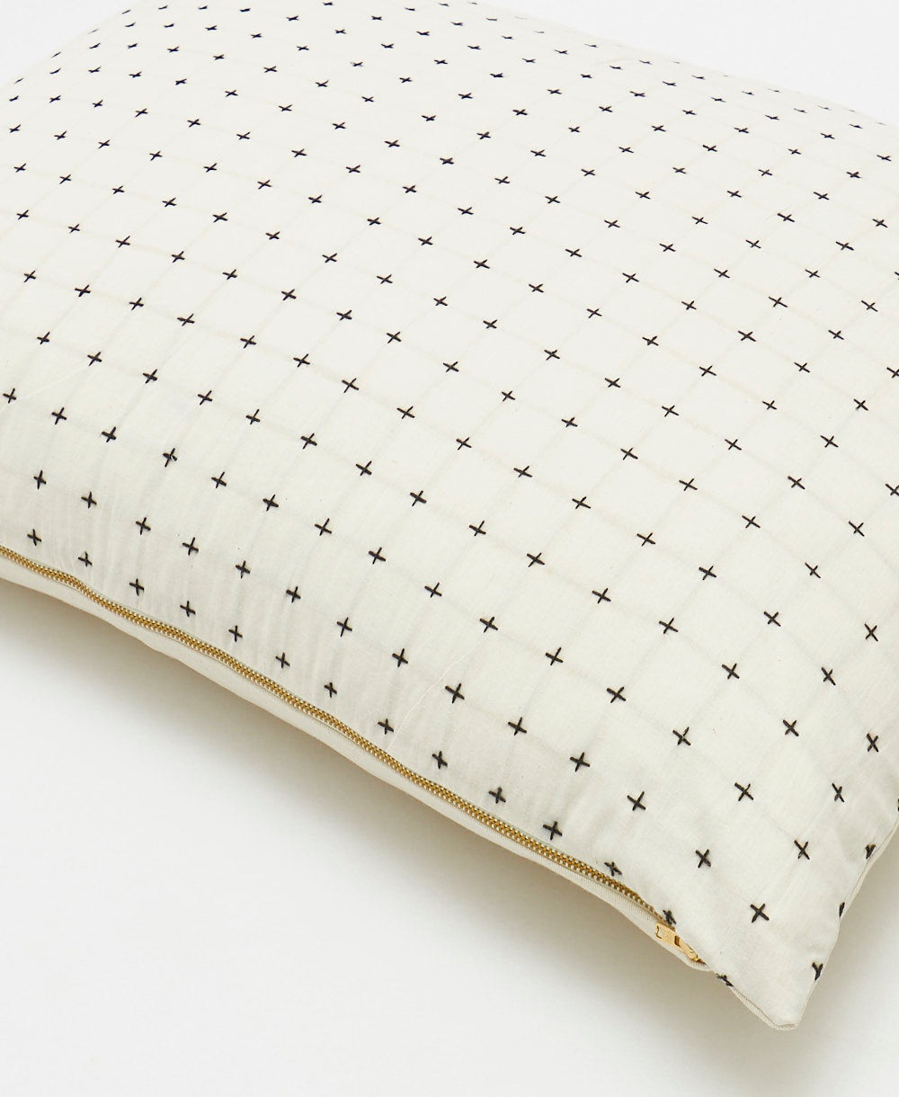 organic cotton pillow sham in white with black cross-stitching and brass tone metal zipper