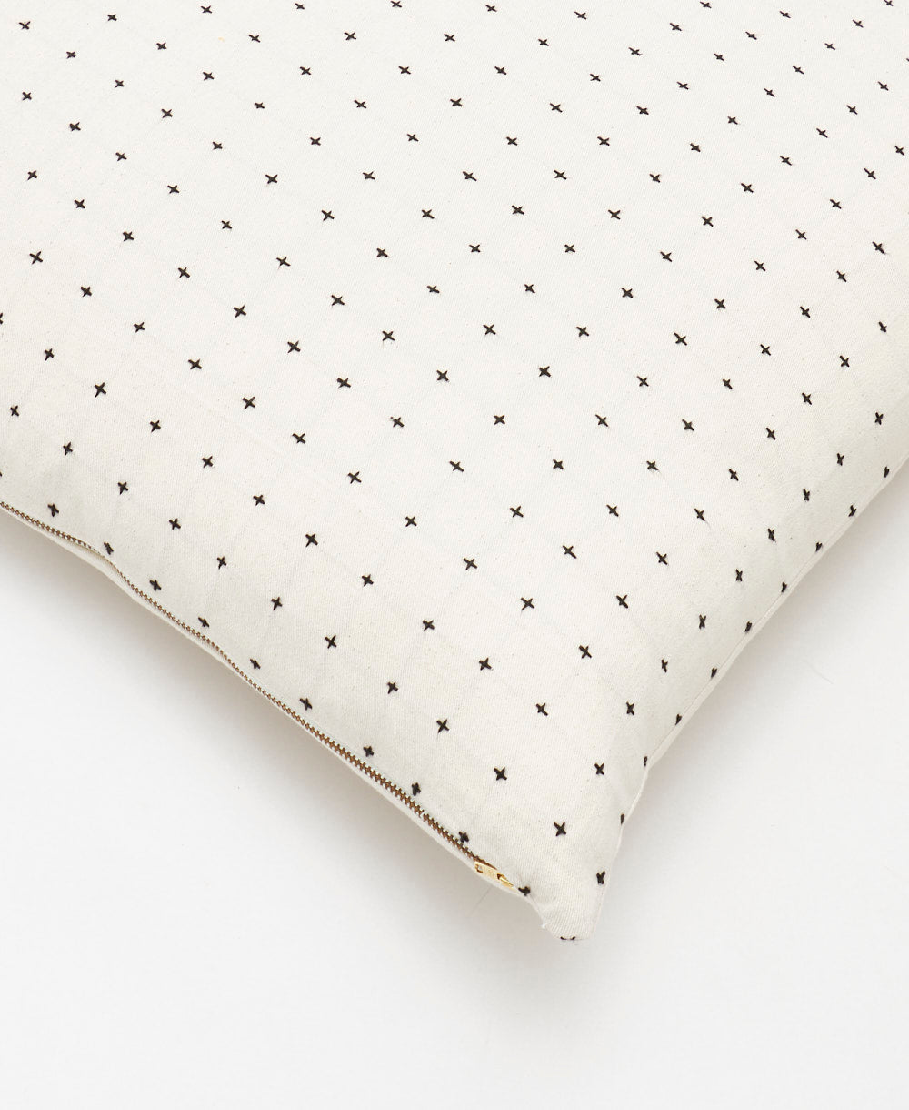 bone ivory throw pillow with black cross-stitch embroidery and metal zipper closure