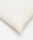 bone ivory throw pillow with black cross-stitch embroidery and metal zipper closure