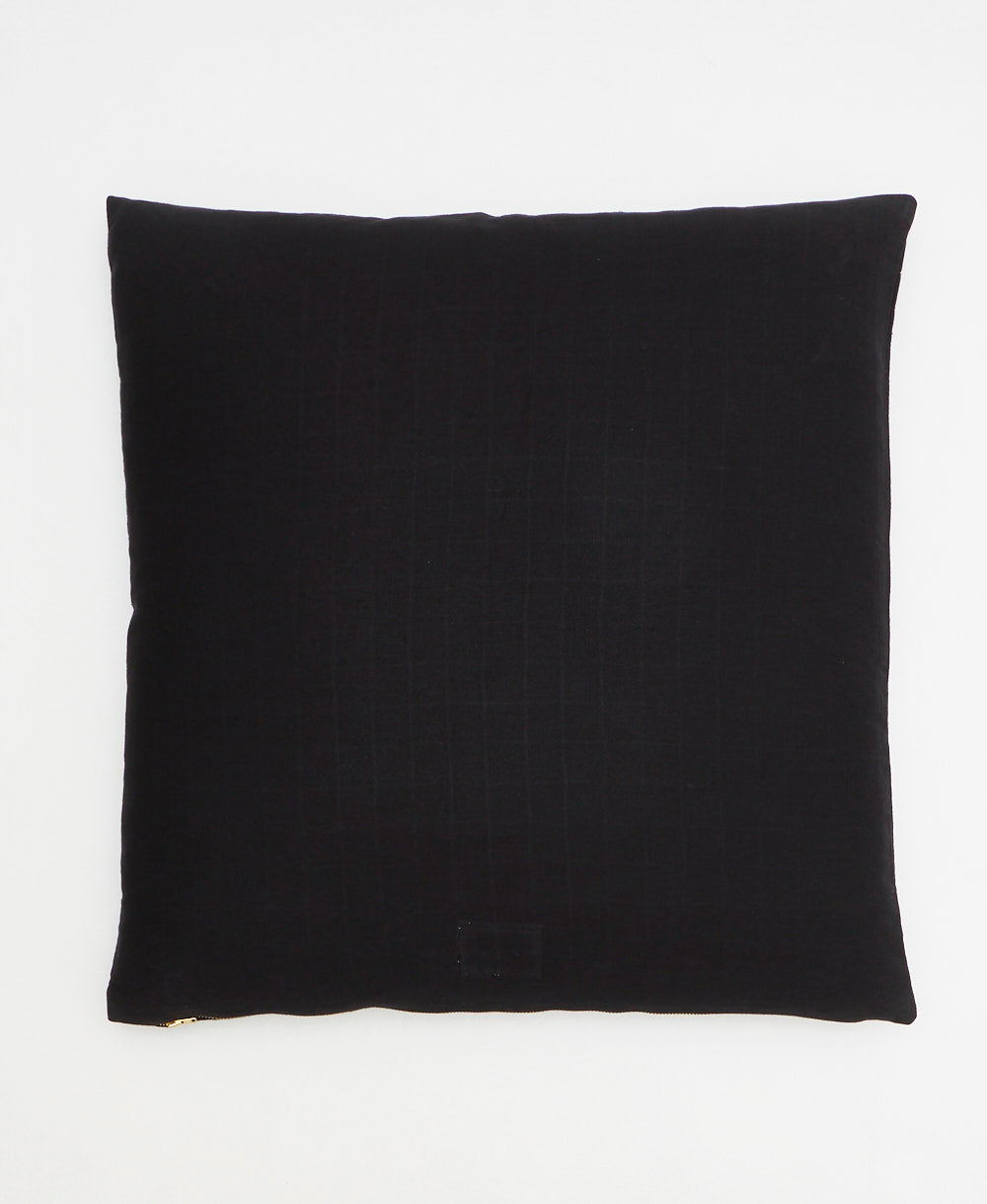 back of black throw pillow with cross-stitch pattern
