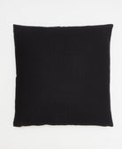 back of black throw pillow with cross-stitch pattern