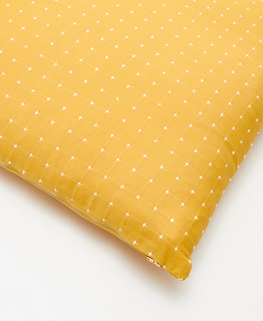 Yellow pillow with white star pattern on a white background