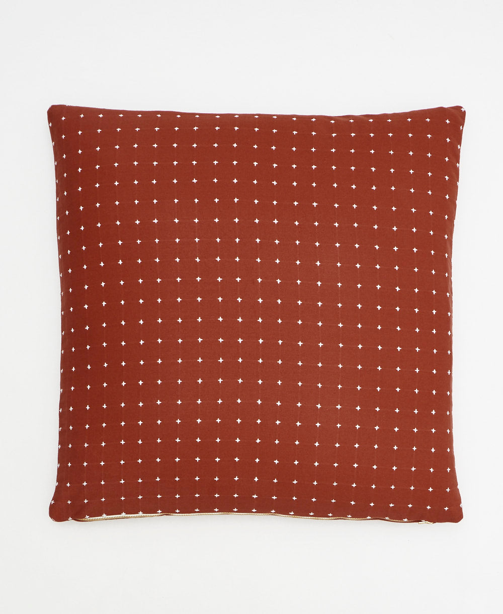 rust red and white cross-stitch throw pillow on white background