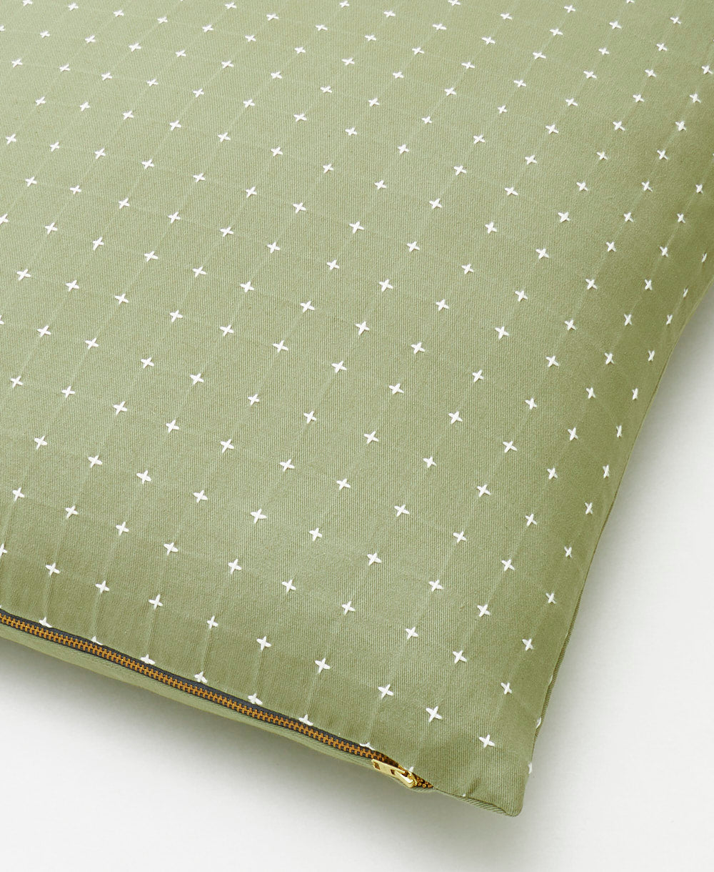 sage green cross-stitch throw pillow with brass-tone metal zipper closure