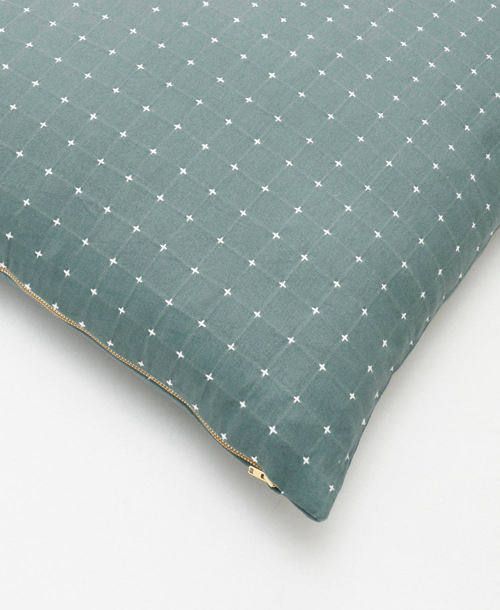 spruce green throw pillow with white cross-stitch embroidery and brass gold tone zipper