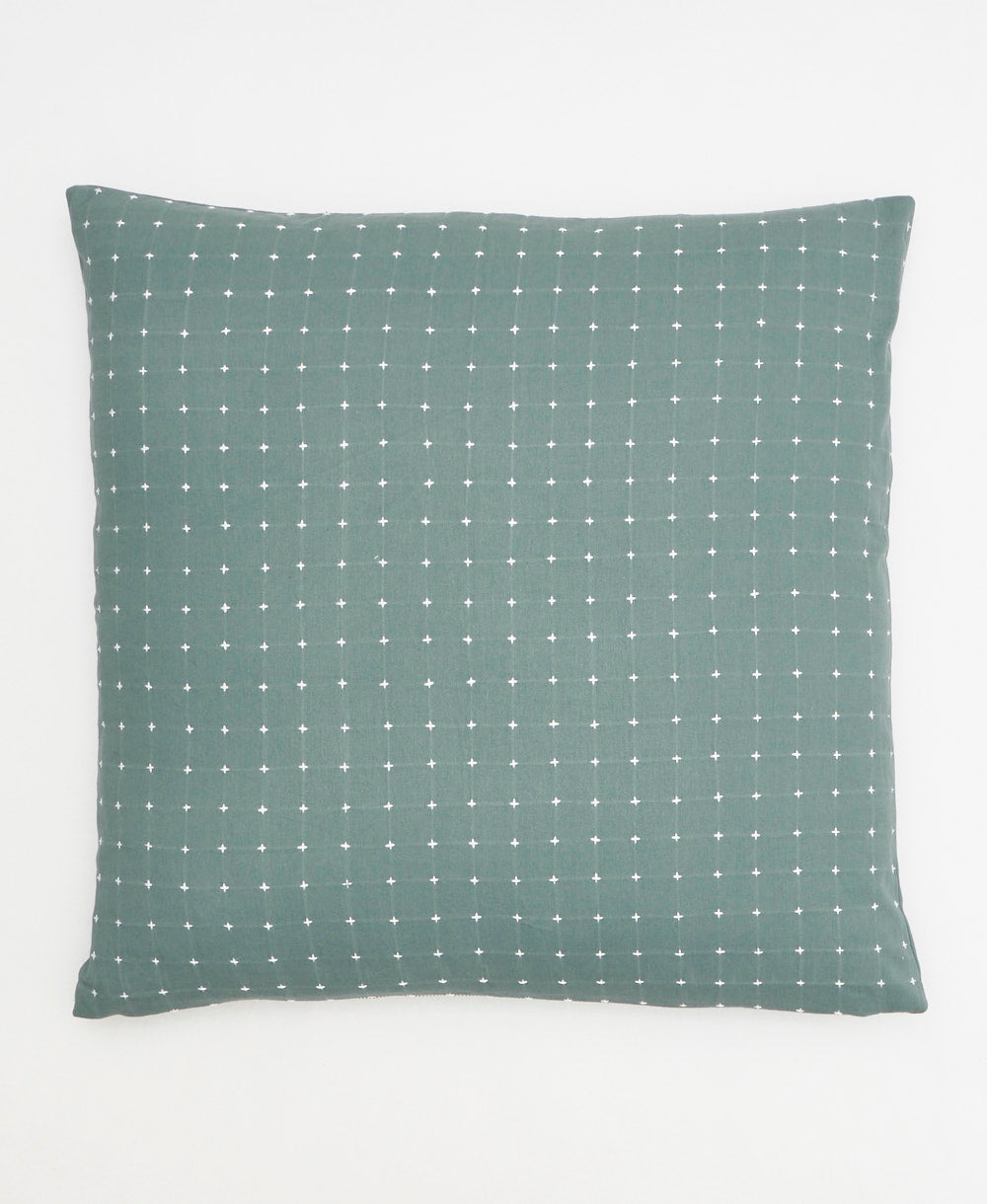 sage green throw pillow with tiny white cross-stitch design