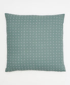 sage green throw pillow with tiny white cross-stitch design