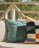Decorative pillows on a couch with a blurred outdoor background