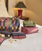 green and purple toiletry bags sitting on white bedspread
