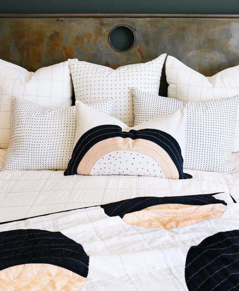 Quilted bedspread with geometric pattern on a bed with pillows