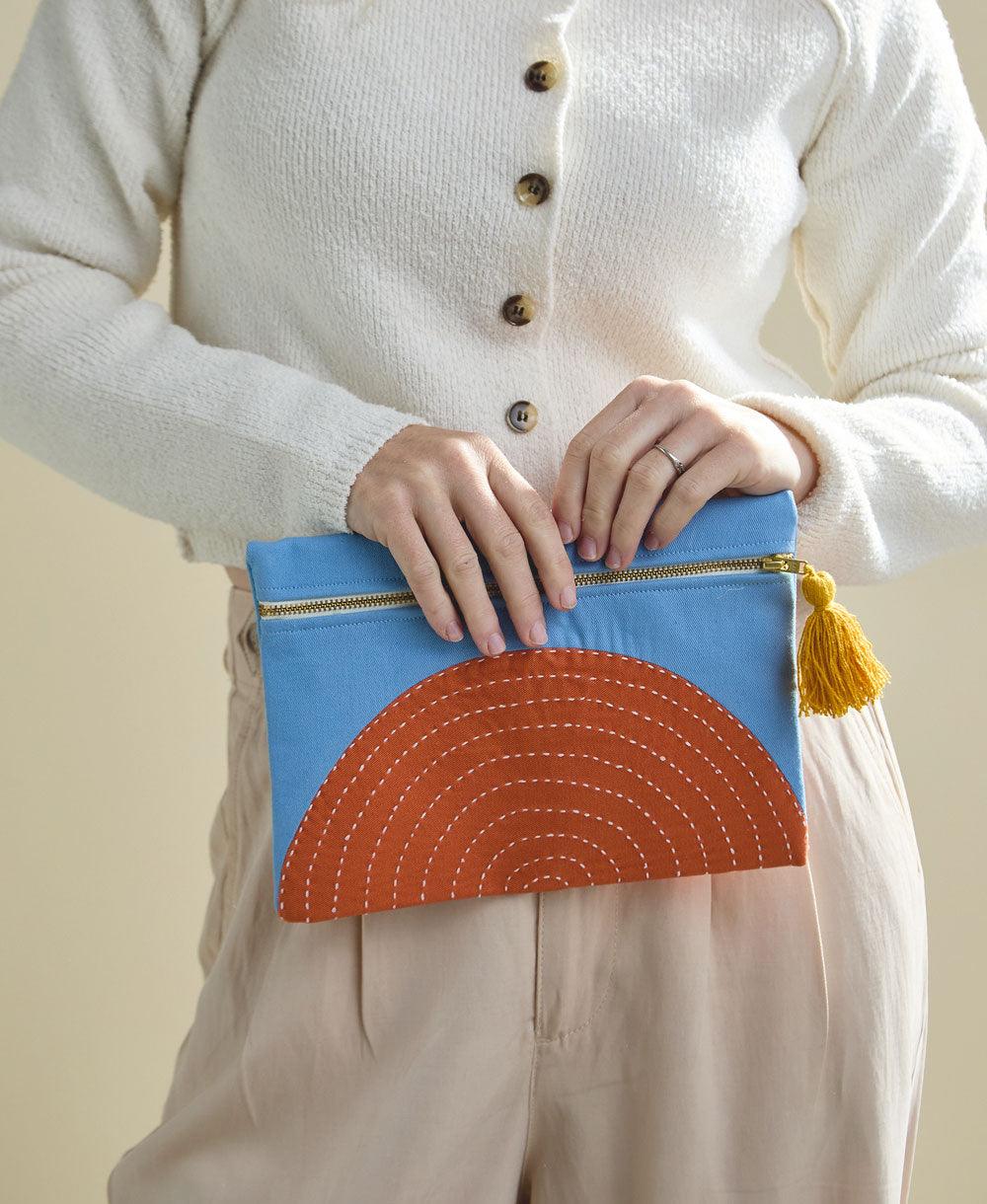 woman holding small sky blue pouch handmade in India from 100% organic cotton