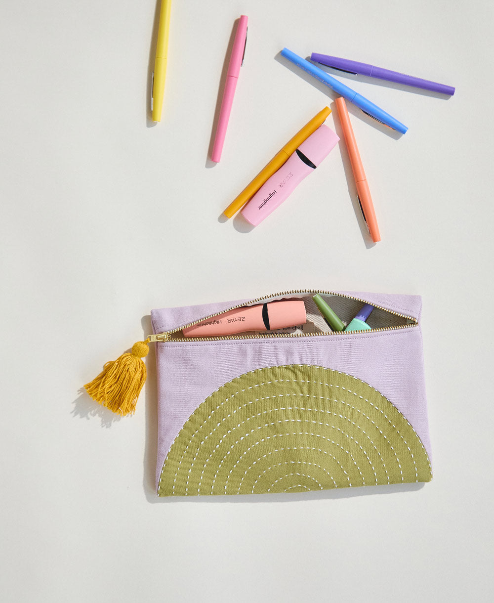 lilac and olive green pouch with colorful pens spilling out of it