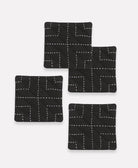 Set of four black coasters with white line patterns on a white background