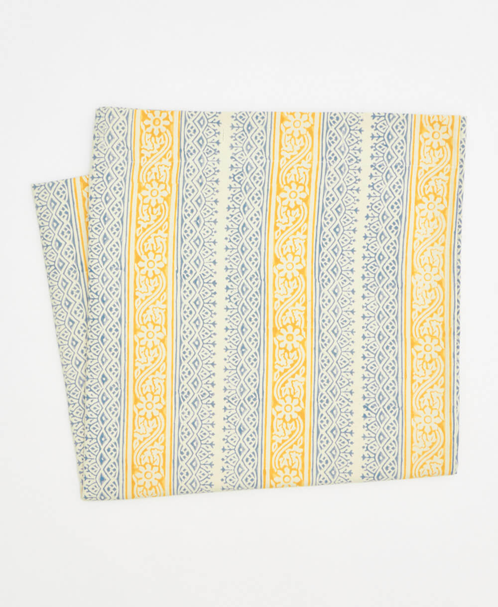 Folded fabric with yellow and gray pattern on a white background