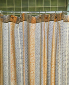 Patterned shower curtain with decorative hooks on a tiled bathroom wall