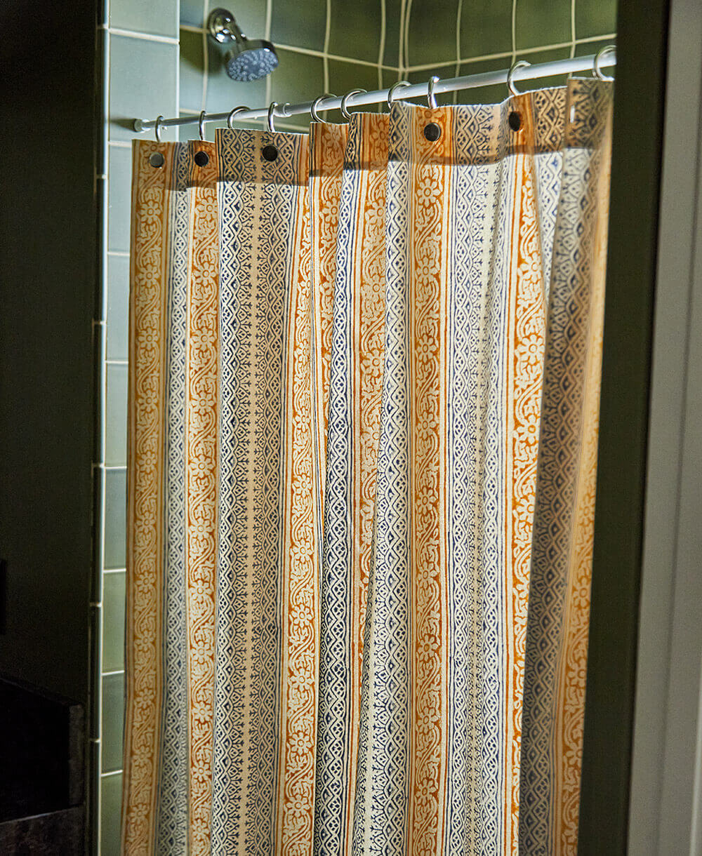 Patterned shower curtain hanging on a rod in a bathroom