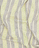 Close-up of a fabric with intricate green and beige pattern