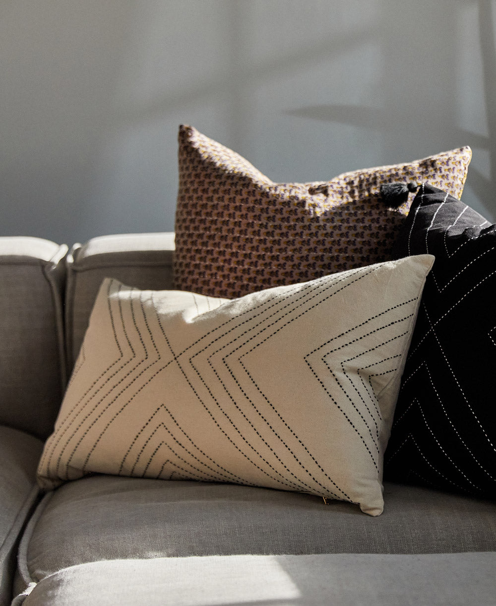 Decorative pillows on a gray sofa with a neutral background