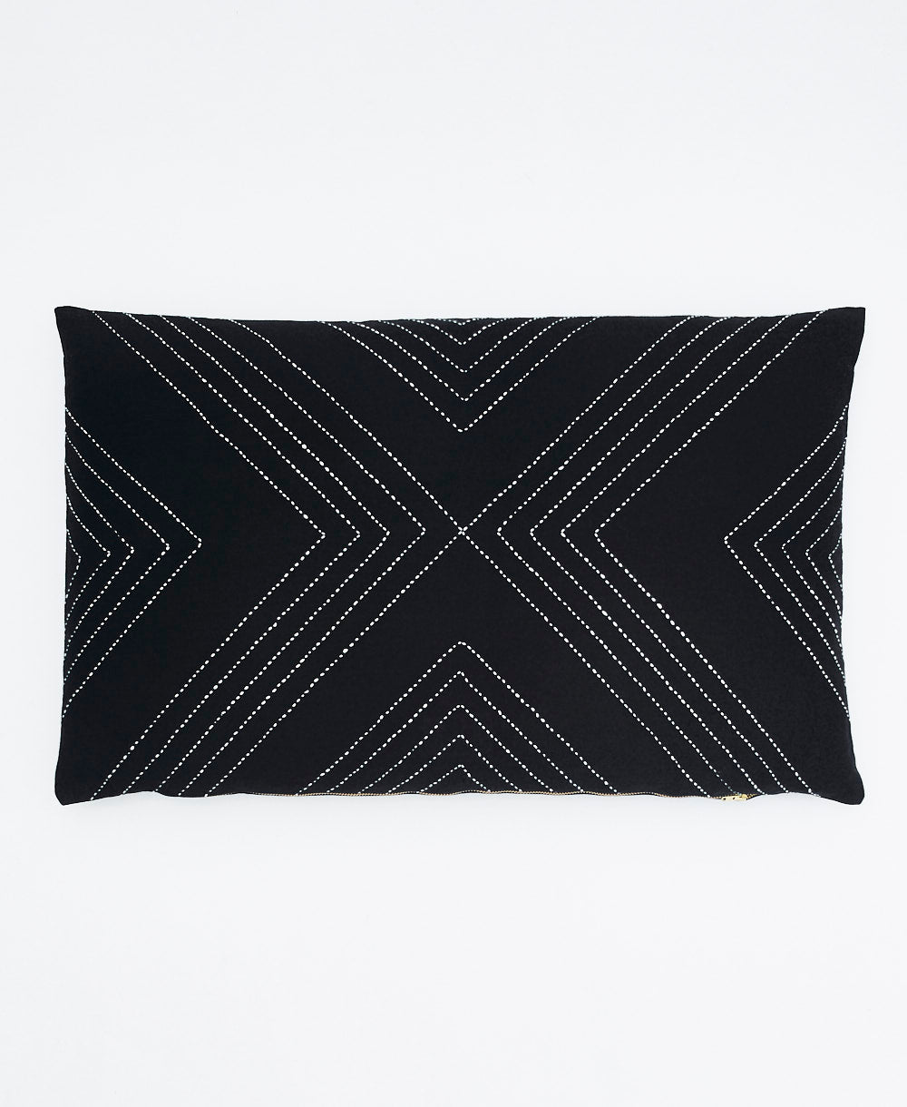 Black pillow with white geometric pattern on a white background