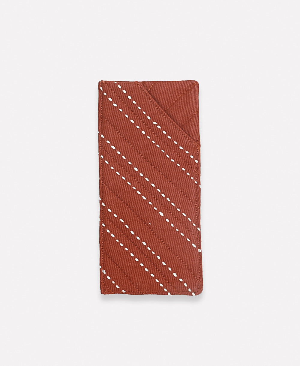 rust red glasses case with white hand-stitched embroidery