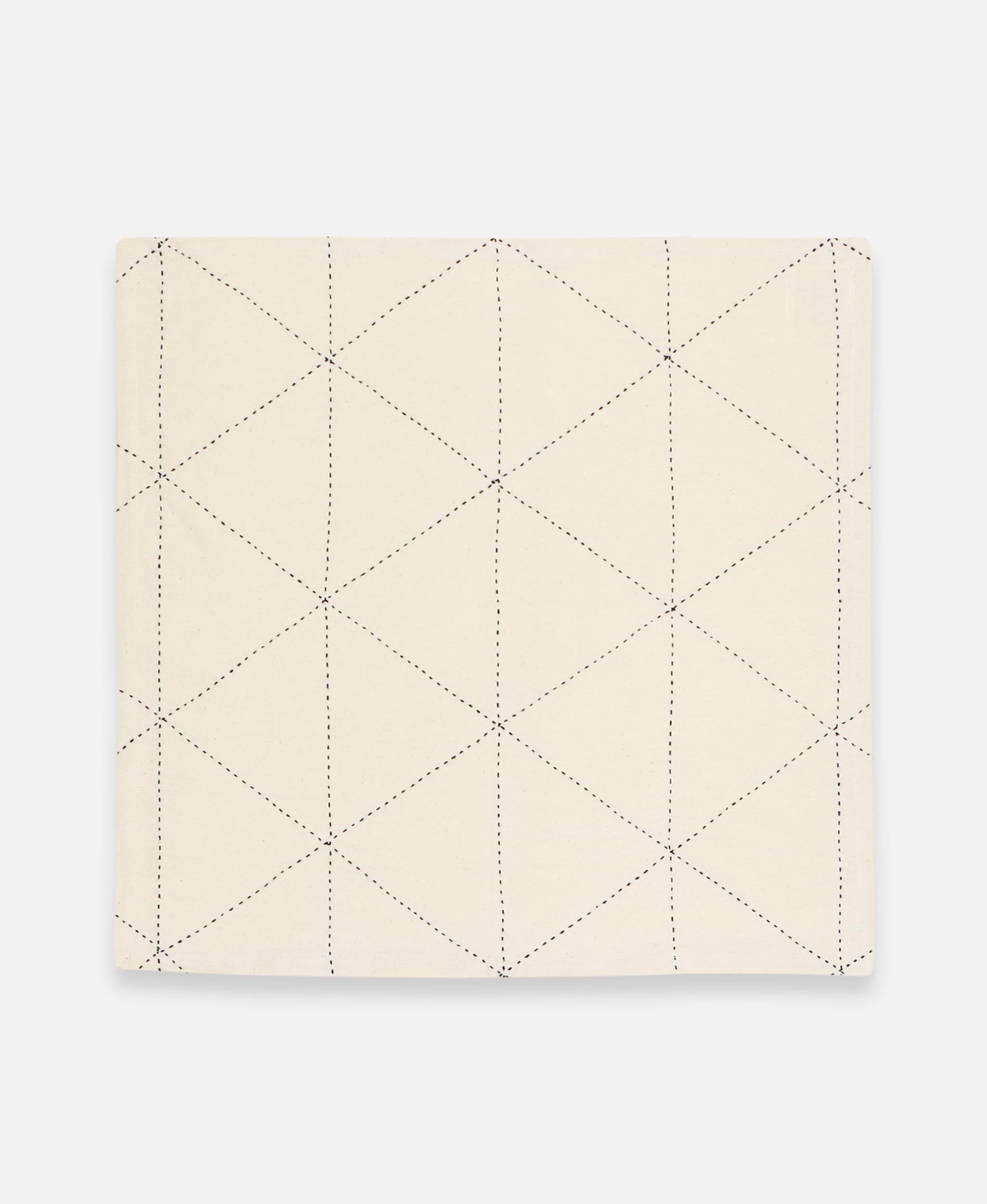 Quilted beige fabric on a light gray background