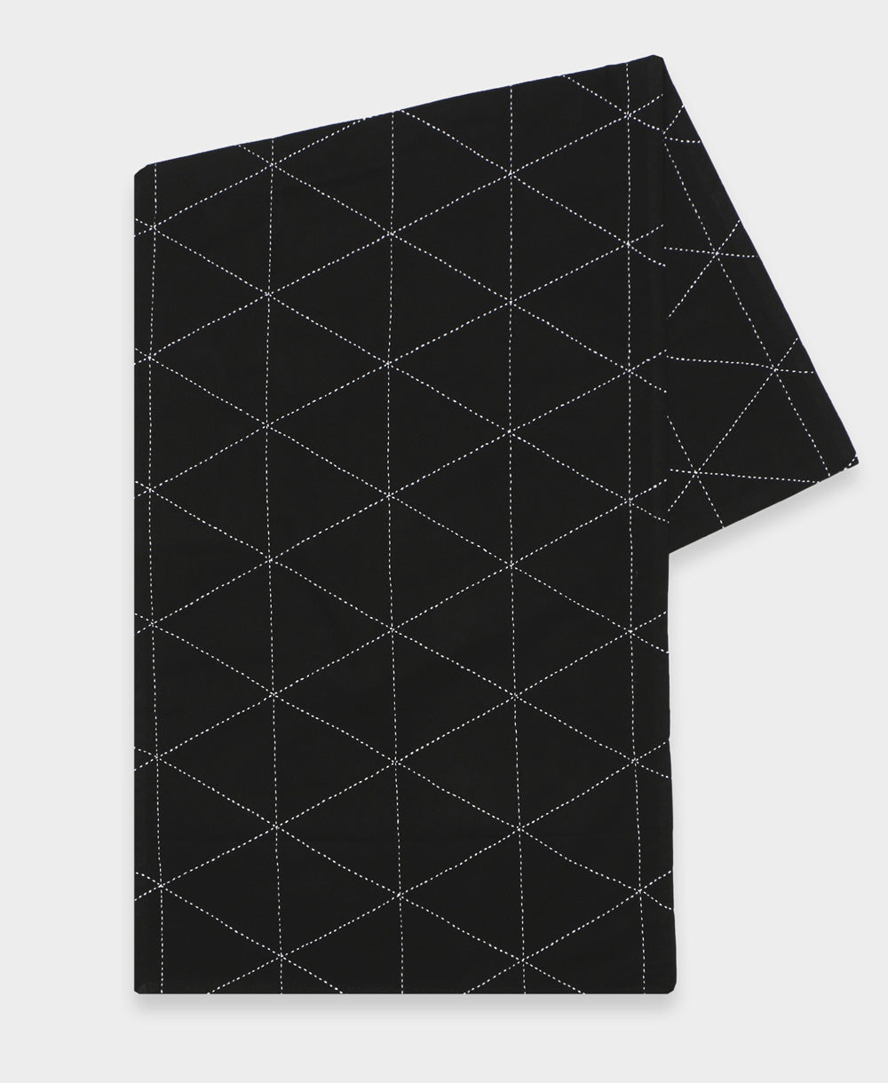 black embroidered table runner with white geometric triangle stitch pattern
