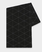 Black embroidered table runner with geometric pattern on a light gray background