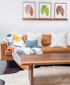 Brown leather sofa with colorful blanket and pillows in a living room setting