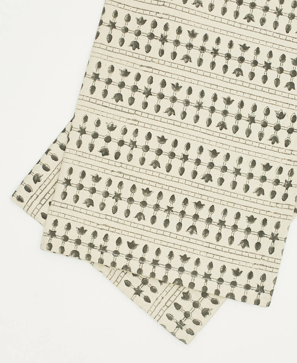 Two folded fabric napkins with a floral pattern on a beige background