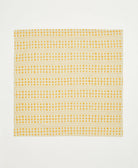 Yellow and white checkered pattern on a block print cotton napkin on a plain background