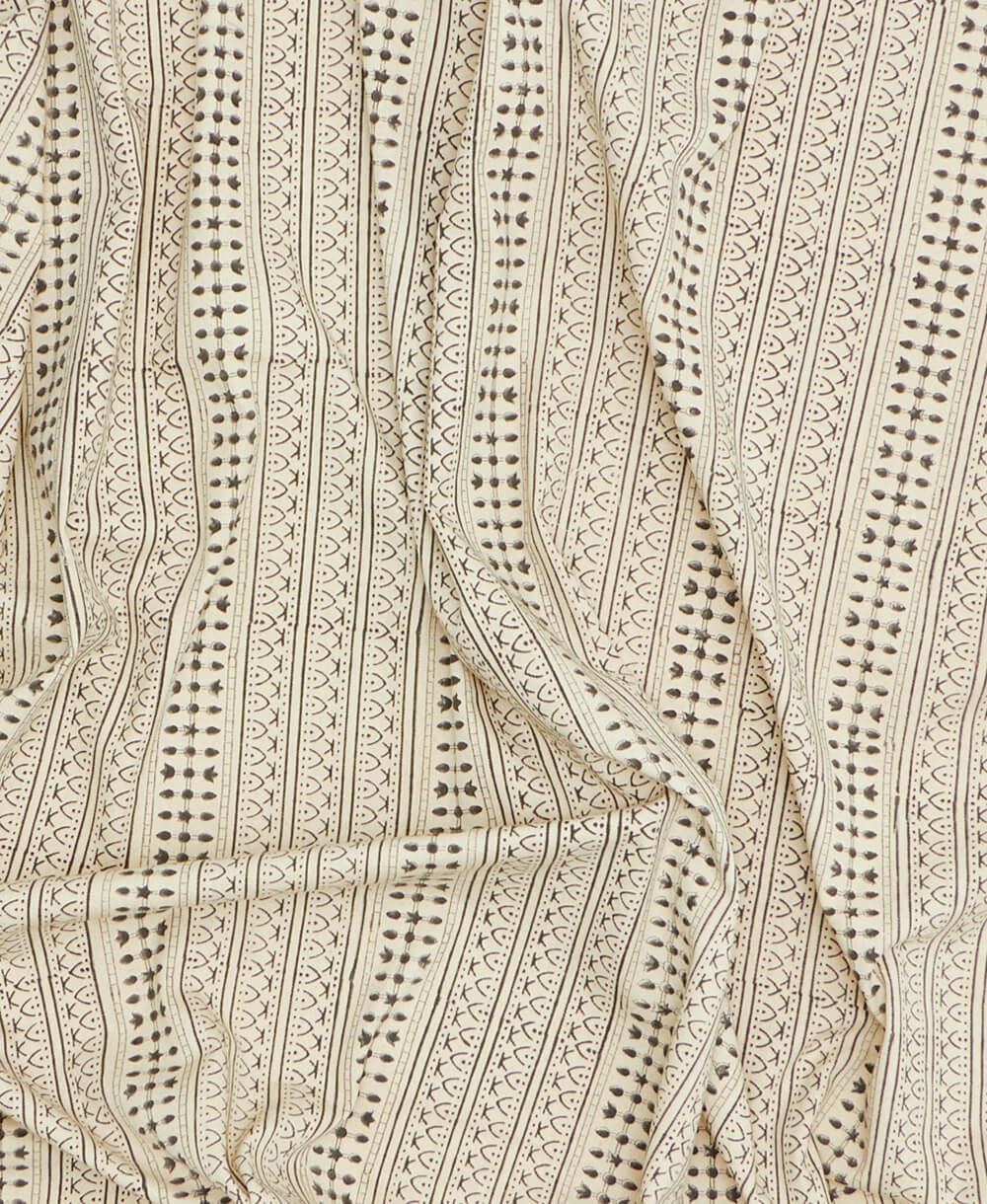 Close-up of a fabric with a detailed pattern on a beige background