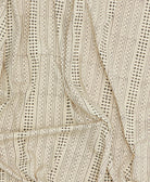 Close-up of a fabric with a detailed pattern on a beige background
