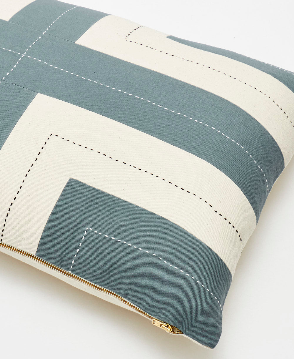Close-up of a striped pillow with spruce green and white colors on a light background