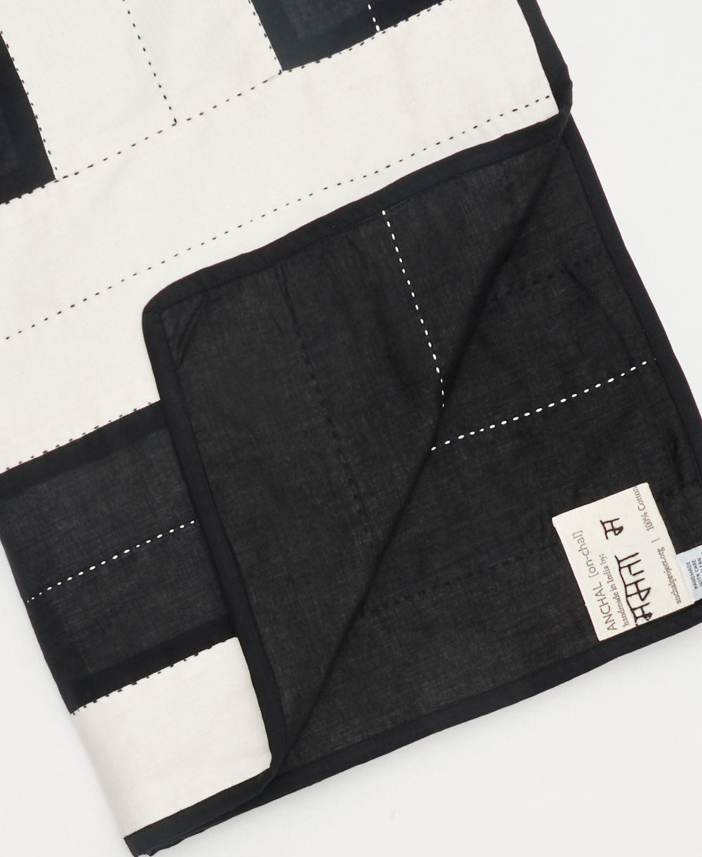 Black and white quilt with a visible brand label on a white background