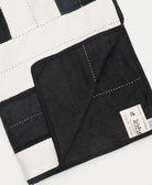 Black and white quilt with a visible brand label on a white background