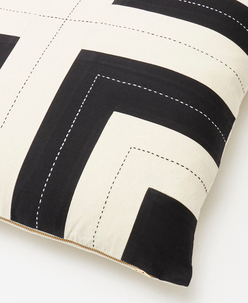 detail of interlock throw pillow in charcoal with a brass-toned YKK zipper closure