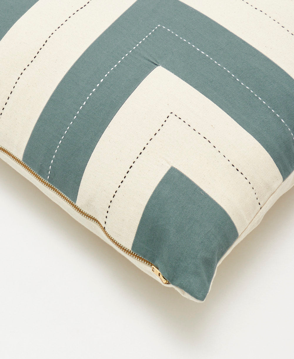 Close-up of a square pillow with green and beige stripes on a white background